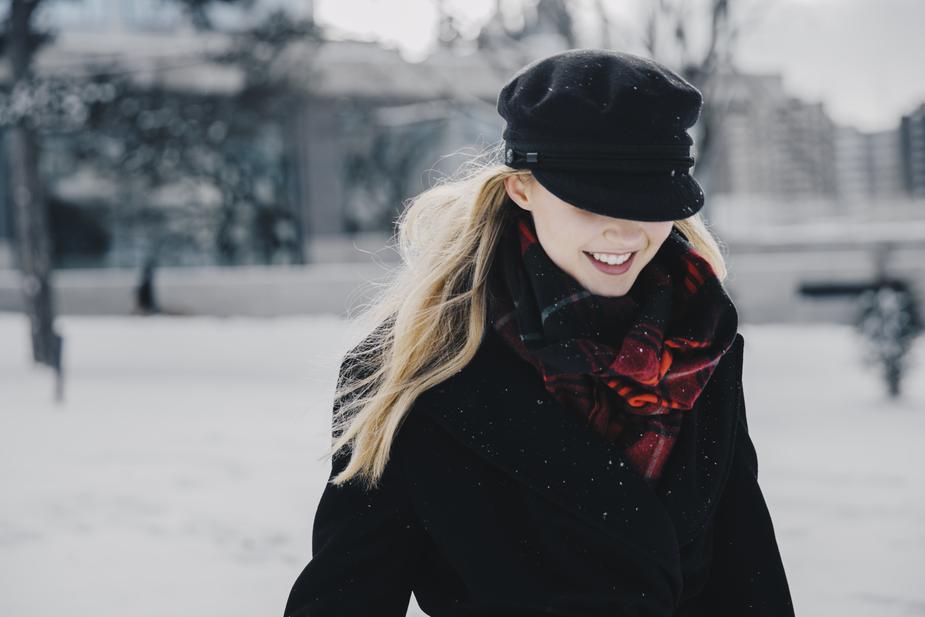 a woman is standing on a bench in the snow
