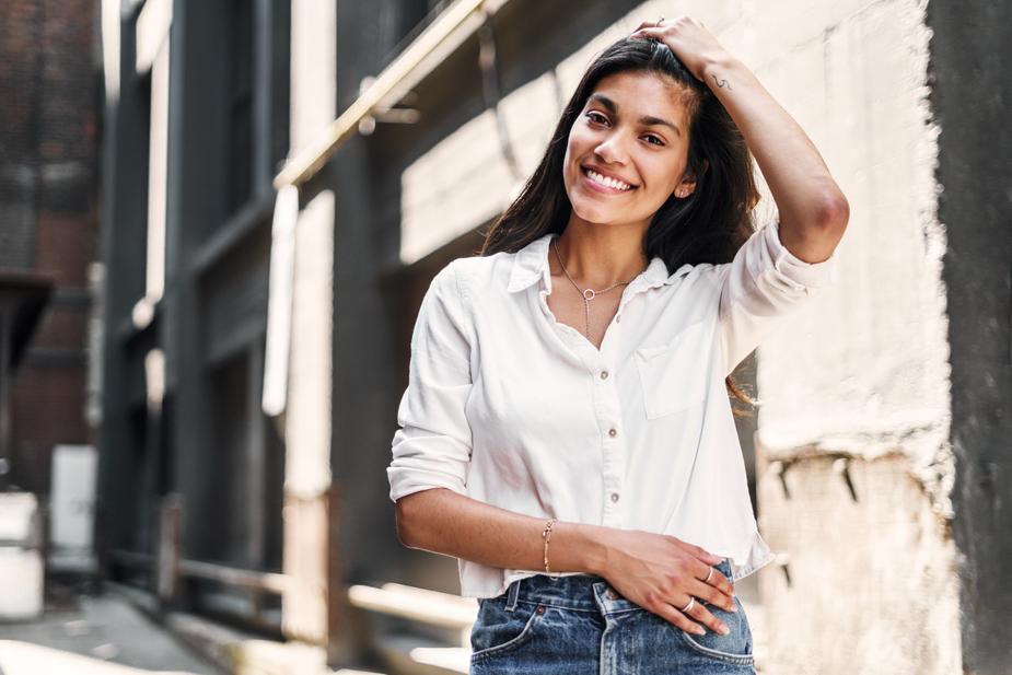 a woman standing in front of a building talking on a cell phone